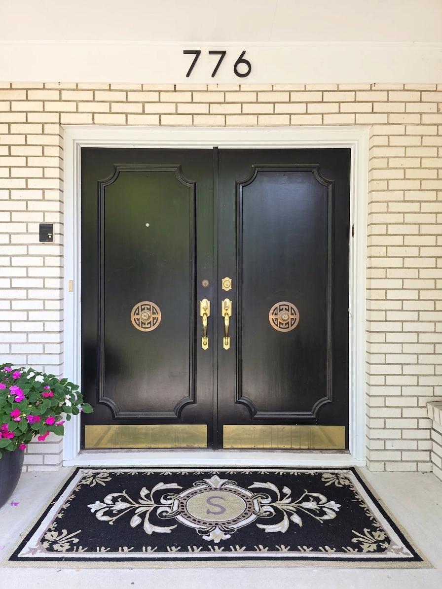 Elegant double-door entry with classic detailing and brass accents creates a memorable first impression.