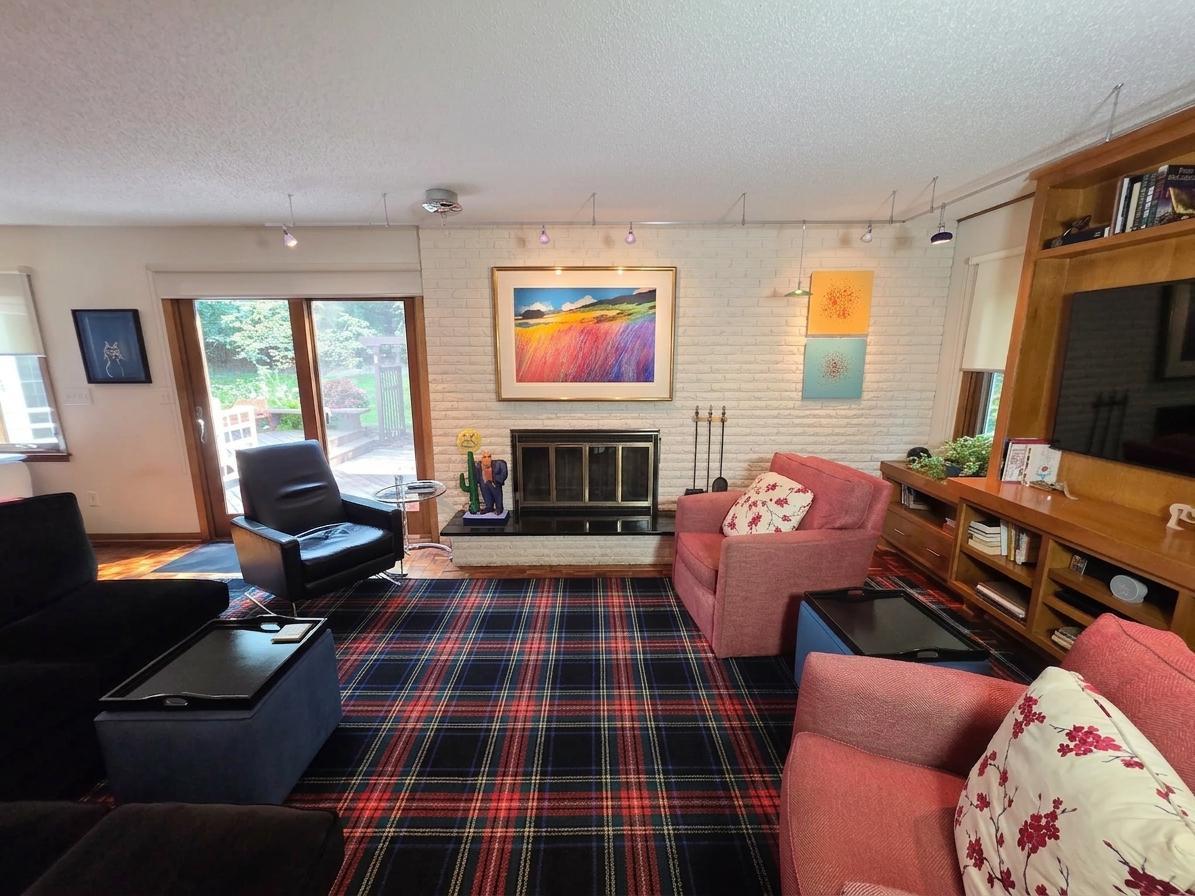 Inviting family room with a full brick fireplace, custom built-in entertainment center, abundant natural light, and direct access to the deck and backyard.