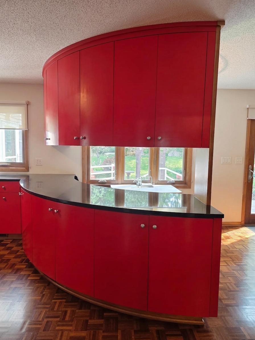 Striking custom curved cabinetry showcases the home's distinctive design, abundant storage, and attention to architectural detail.