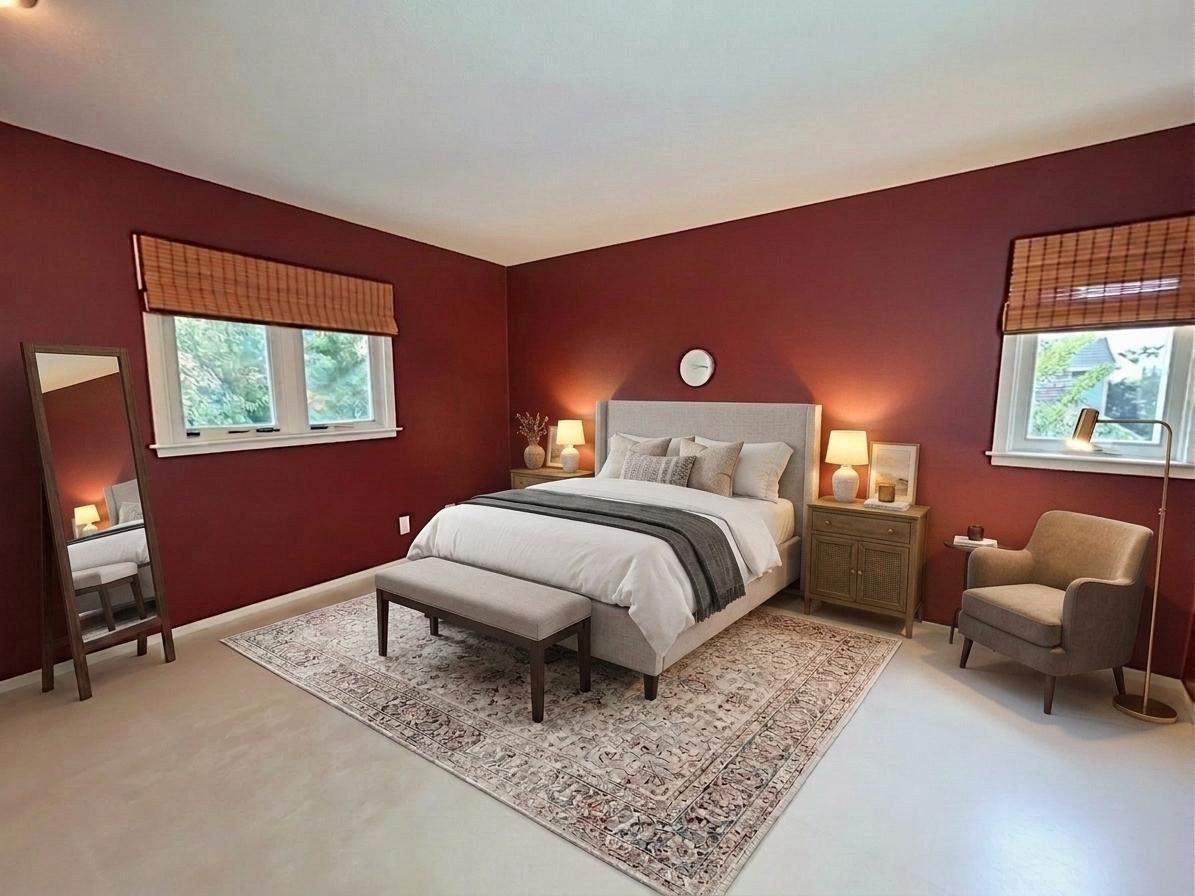 Generously sized bedroom with windows on two sides, offering excellent natural light and ample room for a complete furniture arrangement.