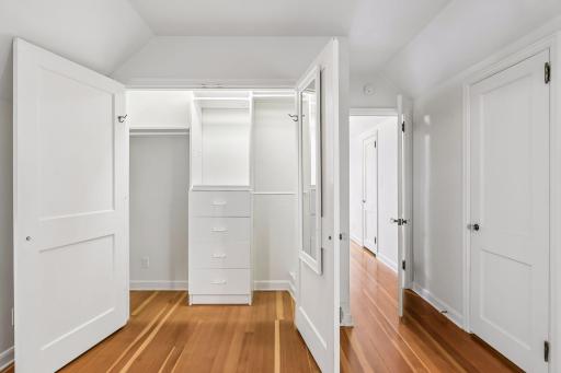 Custom built closet with rods and drawers. Additional walk-in closet to the right and two more closets are found in the hallway.