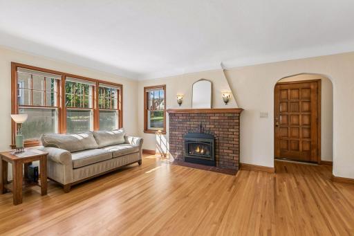 Bright and living room with wall of west facing windows and gas fireplace - new insert 2024.