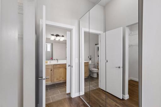 Mirrored cabinets fit the space perfectly on the right side of the walk-in closet.