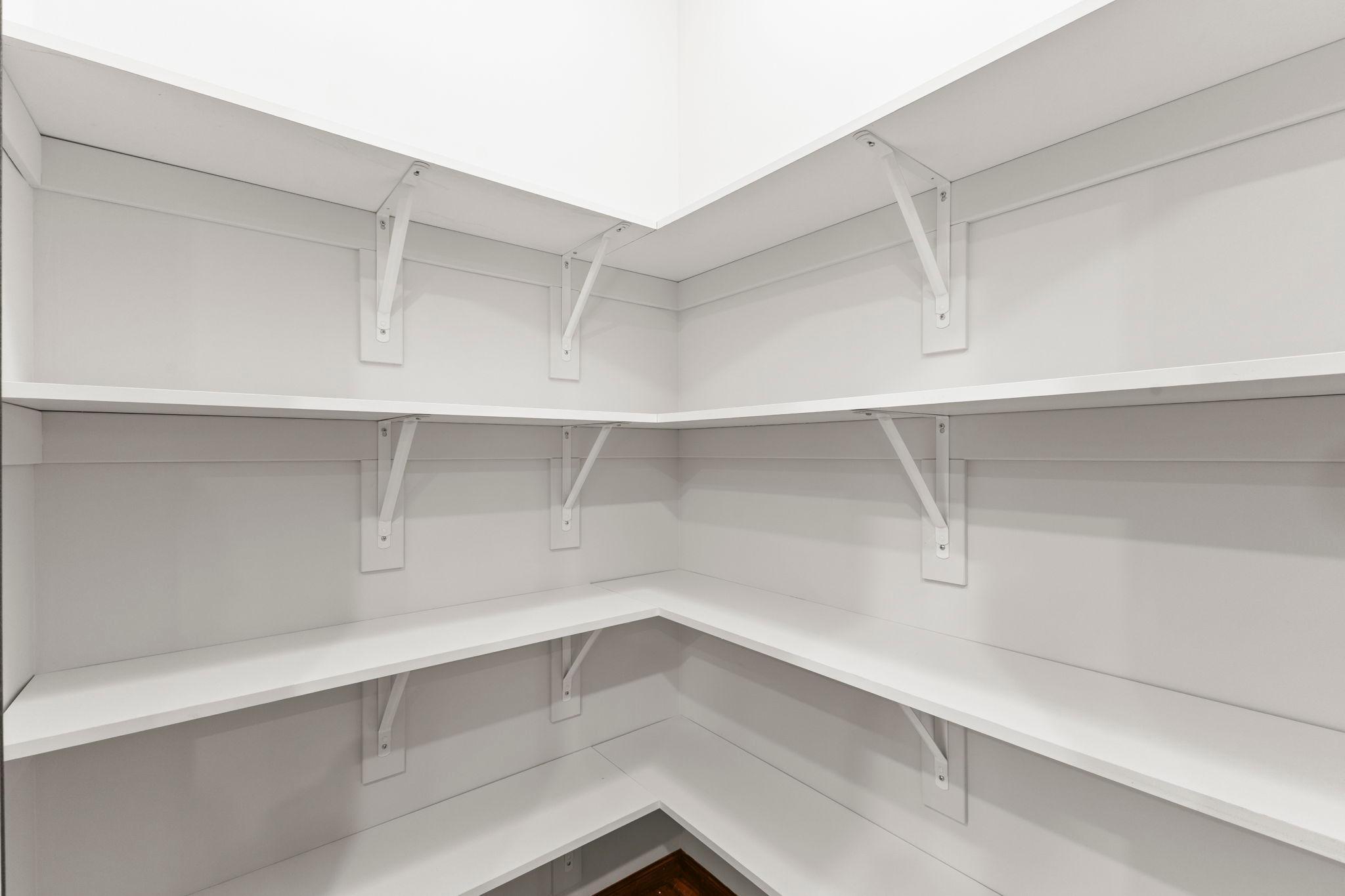 Walk-in kitchen pantry with solid shelves
