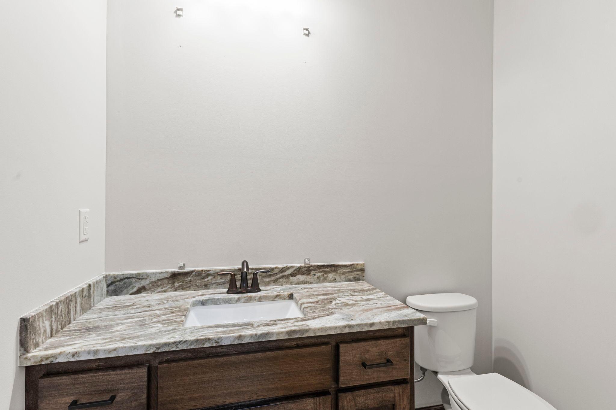 Half-bath conveniently located next to the garage service door