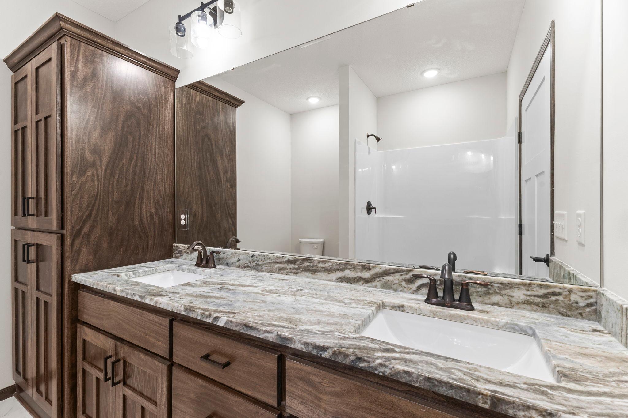 Dual vanities, custom cabinets, and granite countertop