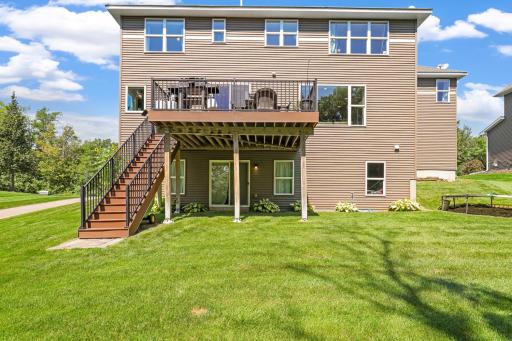 Highlight of the maintenance-free upper deck with direct staircase access to the fully fenced-in or sprawling green lawn below, complemented by a walk-out patio area beneath.