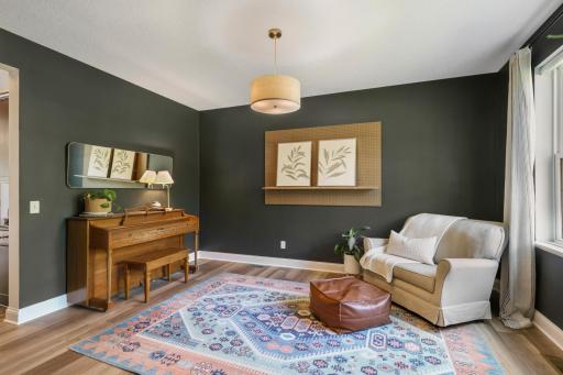 Stylish sitting room with rich charcoal walls and a large window providing plenty of natural light. A cozy, inviting space with a polished yet comfortable feel.