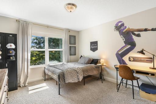Sunlit Secondary Bedroom: Spacious upper-level bedroom offering plush carpet, a bright double window framing private views, and plenty of space for a full bed and study desk setup.