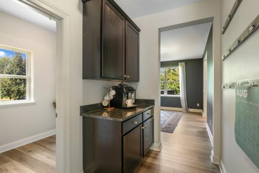 Dedicated built-in beverage/coffee station with matching dark cabinetry and granite counter, perfect for morning routines or entertaining.