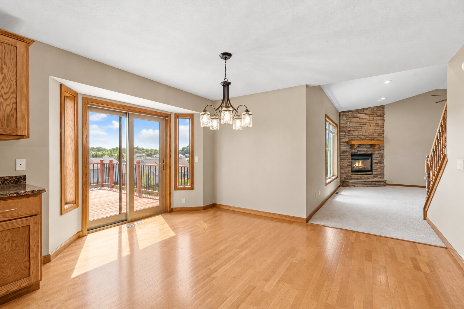 Dining area opens to the elevated deck and overlooks the inviting great room with stone fireplace