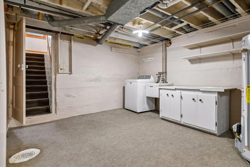 The lower level features a bright laundry room with a utility sink and folding counter.
