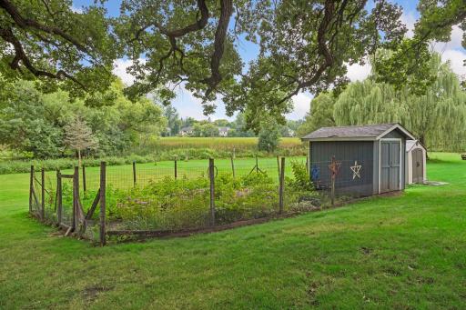 Already laid out for you, the fenced-in vegetable garden enjoys a storage shed to help keep your gardening tools nearby.