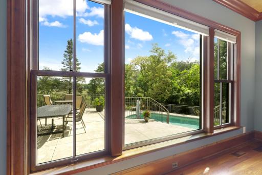 The dining room’s expansive window frames picturesque views of the terrace and pool, creating a stunning backdrop for entertaining.