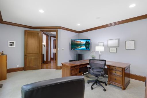 Expansive windows bring natural light into the generous office, while built-in credenzas provide elegant, thoughtfully integrated storage.