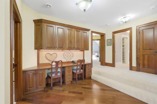 An open landing serves as a thoughtful transition to the three upper-level bedrooms, with two built-in desks tucked seamlessly into the space.