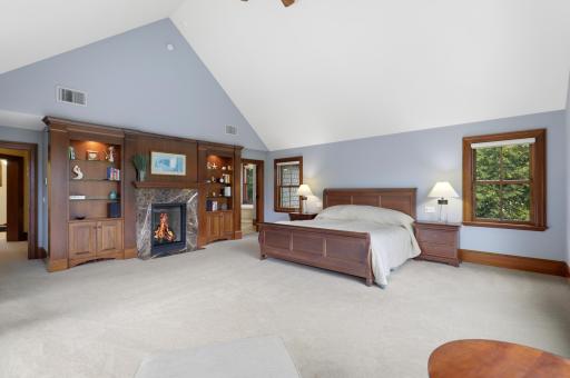 Expansive views and exceptional privacy define the generously sized primary bedroom, where a fireplace adds warmth and character. The luxurious ensuite offers a soaking tub, steam shower, and heated floors.