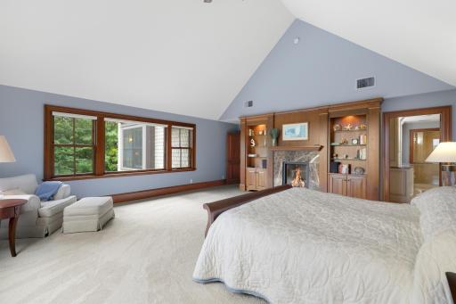 Expansive views and exceptional privacy define the generously sized primary bedroom, where a fireplace adds warmth and character. The luxurious ensuite offers a soaking tub, steam shower, and heated floors.