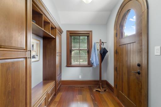 A custom built-in drop zone with shelving and bench seating keeps everyday essentials neatly organized just inside the entry.