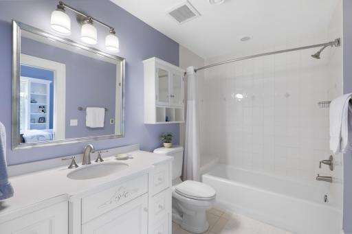 Two private ensuite bedrooms on the upper level feature walk-in closets and picture windows with built-in benches, creating comfortable retreats filled with natural light.