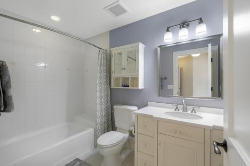 Two private ensuite bedrooms on the upper level feature walk-in closets and picture windows with built-in benches, creating comfortable retreats filled with natural light.