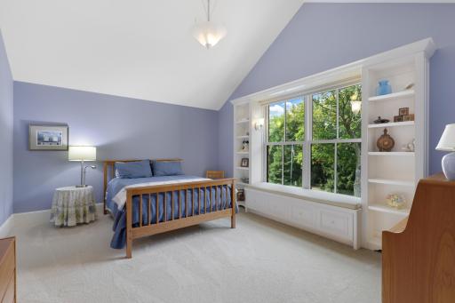 Two private ensuite bedrooms on the upper level feature walk-in closets and picture windows with built-in benches, creating comfortable retreats filled with natural light.