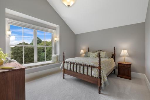 Two private ensuite bedrooms on the upper level feature walk-in closets and picture windows with built-in benches, creating comfortable retreats filled with natural light.