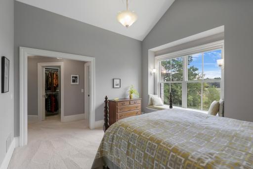 Two private ensuite bedrooms on the upper level feature walk-in closets and picture windows with built-in benches, creating comfortable retreats filled with natural light.