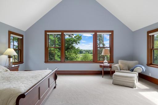 Expansive views and exceptional privacy define the generously sized primary bedroom, where a fireplace adds warmth and character. The luxurious ensuite offers a soaking tub, steam shower, and heated floors.