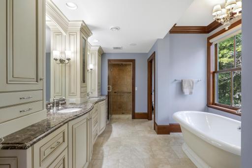 Expansive views and exceptional privacy define the generously sized primary bedroom, where a fireplace adds warmth and character. The luxurious ensuite offers a soaking tub, steam shower, and heated floors.