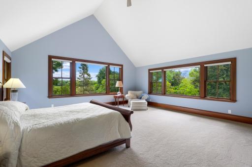 Expansive views and exceptional privacy define the generously sized primary bedroom, where a fireplace adds warmth and character. The luxurious ensuite offers a soaking tub, steam shower, and heated floors.