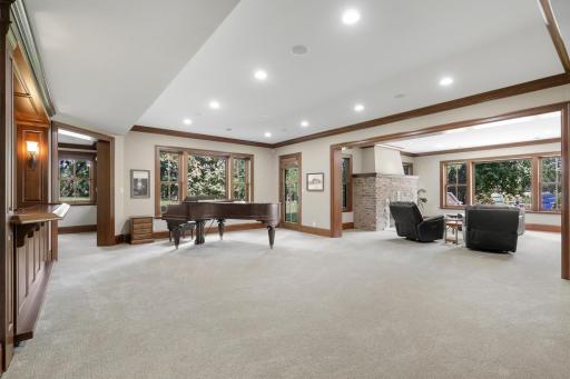 The walk-out lower level offers a spacious recreation room that flows seamlessly into a welcoming family room, anchored by a fireplace.