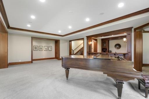 The walk-out lower level offers a spacious recreation room that flows seamlessly into a welcoming family room, anchored by a fireplace.