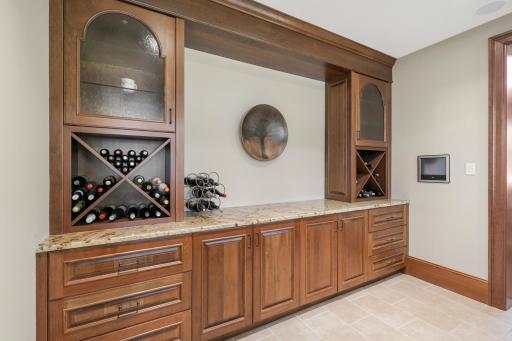 The full wet bar showcases beautifully detailed custom cabinetry and woodwork, bringing warmth and character to the lower-level entertaining space.