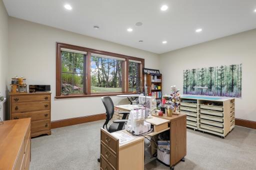 The lower-level fourth bedroom features a cedar closet and is currently appointed as a charming sewing room, offering flexibility for a variety of uses.