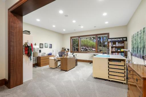 The lower-level fourth bedroom features a cedar closet and is currently appointed as a charming sewing room, offering flexibility for a variety of uses.