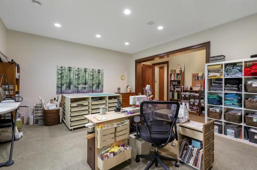 The lower-level fourth bedroom features a cedar closet and is currently appointed as a charming sewing room, offering flexibility for a variety of uses.