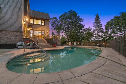 The private backyard oasis centers around an in-ground pool, with multiple terraces creating inviting spaces for lounging and entertaining.