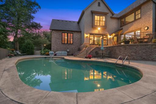 The private backyard oasis centers around an in-ground pool, with multiple terraces creating inviting spaces for lounging and entertaining.