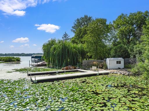 The fenced and gated dock area offers easy access and practical amenities, including a storage shed and room for a golf cart.