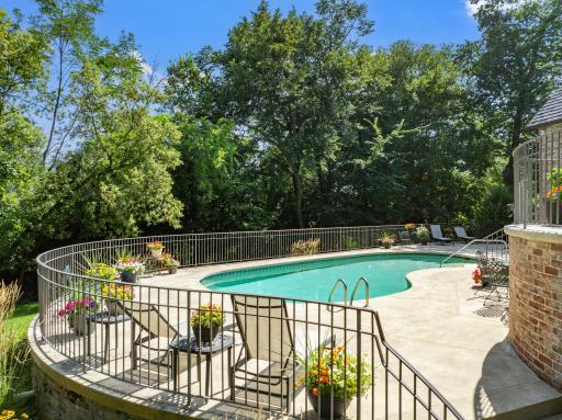 The private backyard oasis centers around an in-ground pool, with multiple terraces creating inviting spaces for lounging and entertaining.