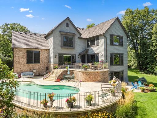 The private backyard oasis centers around an in-ground pool, with multiple terraces creating inviting spaces for lounging and entertaining.