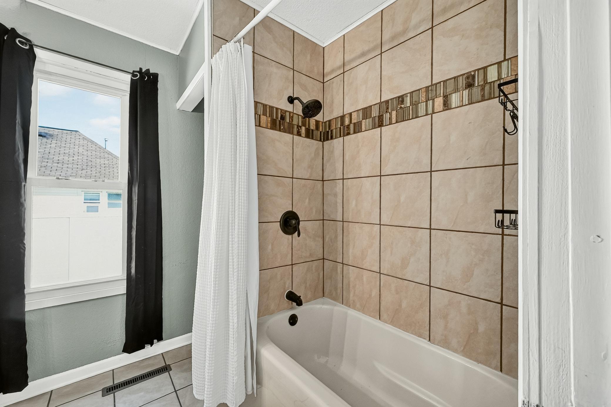 main bath- laundry hookups behind shower for stackable unit