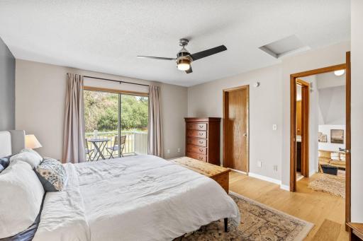Primary bedroom with a sliding glass door to a private balcony and a door to the bathroom.