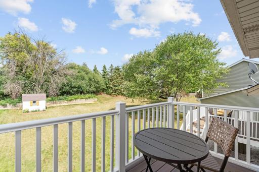 Private balcony off the primary bedroom overlooking the backyard and mature trees.