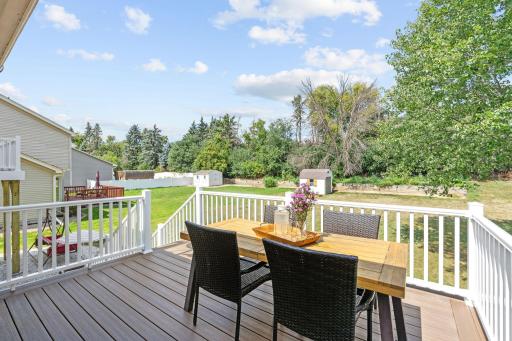 Brand new deck overlooking the backyard with composite decking, white vinyl railing, and room for a full dining set.