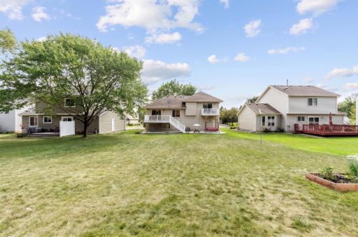 Rear exterior with a raised deck, stairs down to the yard, and a wide open backyard.