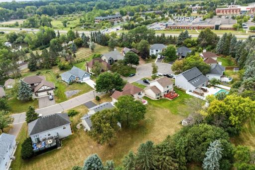 Aerial view of the neighborhood with nearby commercial buildings and open green space.