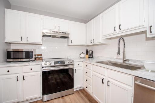 Sleek and updated kitchen featuring high end stainless steel appliances, Kohler sink, subway tile backsplash, and counters.