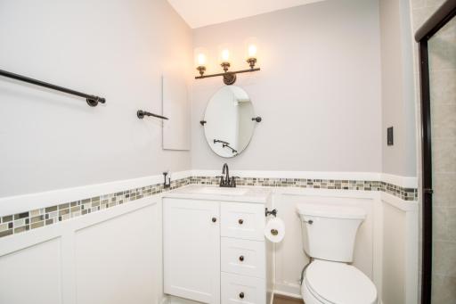 Renovated 3/4 bath with tiled walk-in shower and glass doors.